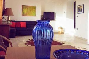 eine blaue Glasvase auf einem Tisch im Wohnzimmer in der Unterkunft DOMUS BARONE in Spongano