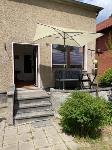 eine Terrasse mit einer Bank und einem Sonnenschirm in der Unterkunft Ferienwohnung Martina in Blankenburg
