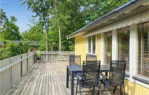 a porch with a black table and chairs on it at 3 Bedroom Nice Home In Fjlkinge in Fjälkinge