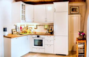 - une cuisine blanche avec des placards blancs et un réfrigérateur dans l'établissement Bioagriturismo Podere Montisi, à Calenzano