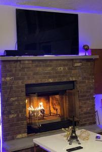a brick fireplace with a fire in it at Oceans - KING BED Cabin Loft & Fireplace in Tobyhanna
