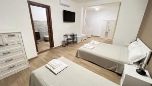 1 dormitorio con 2 camas, tocador y espejo en Cala Portavecchia, en Monopoli