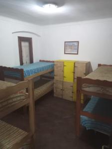 Habitación con 3 literas y armarios de madera. en Puerto Nómade Hostel Internacional en Mar del Plata