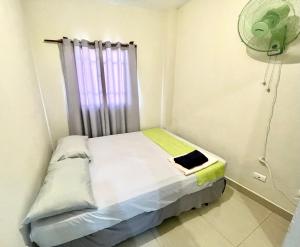 uma pequena cama num quarto com uma ventoinha em Oasis de Paz 1.2 em Jarabacoa