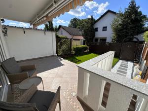 a patio with chairs and a fence and a yard at Haus mit 4 Schlafzimmer, Wohnzimmer und Küche in Heusenstamm