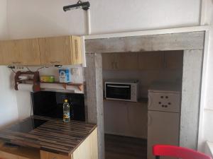 a small kitchen with a door into a kitchen with a microwave at Tony's Old Farm in Begunje na Gorenjskem +17 photos