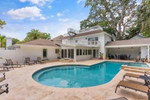 ein Swimmingpool vor einem Haus in der Unterkunft The Southern Whippoorwill - 4226 Fifth Street in Saint Simons Island