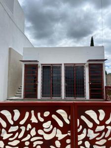 a building with windows and a red fence at Casa Baltazar in Santa María Tonantzintla
