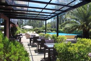 a patio with tables and chairs and a pool at Iveria Elli Hotel in Shekhvetili