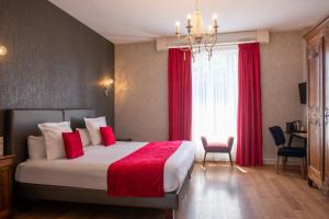 a bedroom with a large bed with red sheets and a window at Relais Des Landes in Ouchamps