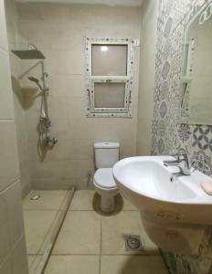 a bathroom with a sink and a toilet and a window at الحدائق المعلقة المصطبة الخامسة بورتو السخنة للعائلات فقط in Ain Sokhna