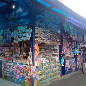 ein Geschäft vor einem Laden mit einem blauen Zelt in der Unterkunft Praia Guaratuba Costa do Sol - 600mt da praia in Bertioga