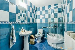 La salle de bains bleue et blanche est pourvue d'un lavabo et de toilettes. dans l'établissement Complex de Pensiuni si Casute la Munte- Durau, à Durau