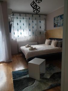 Un dormitorio con una cama y una mesa. en Aurora 2, en Novi Sad