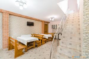 une salle à manger avec des tables et des bancs et un mur en briques dans l'établissement Complex de Pensiuni si Casute la Munte- Durau, à Durau