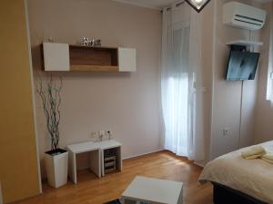 a small white room with a bed and a table at Aurora 2 in Novi Sad