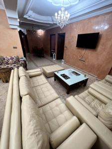un soggiorno con un grande divano e un tavolo di Appartement familiale méditerranéen ad Al-Ḥoseyma