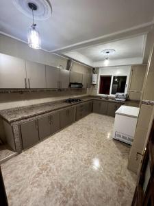 una grande cucina con armadi bianchi e frigorifero bianco di Appartement familiale méditerranéen ad Al-Ḥoseyma
