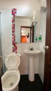 a bathroom with a white toilet and a sink at HOTEL GUADALUPE BGA in Bucaramanga