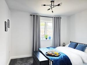 a bedroom with a bed with a tray of food on it at Spacious Two Bedroom Apartment with 2 En-suite Bathrooms in Northampton