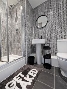 a bathroom with a toilet and a sink and a mirror at Spacious Two Bedroom Apartment with 2 En-suite Bathrooms in Northampton