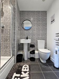 La salle de bains est pourvue d'un lavabo, de toilettes et d'une douche. dans l'établissement Spacious Two Bedroom Apartment with 2 En-suite Bathrooms, à Northampton