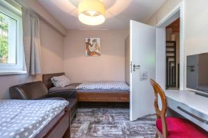 een kleine kamer met een bed en een bank bij BnB Comfort Guesthouse Olten - Lostorf in Lostorf