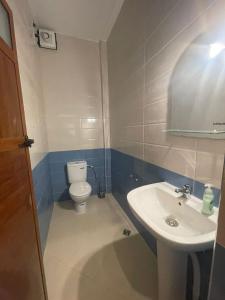 La salle de bains est pourvue de toilettes blanches et d'un lavabo. dans l'établissement Appartement de vacances, à Larache