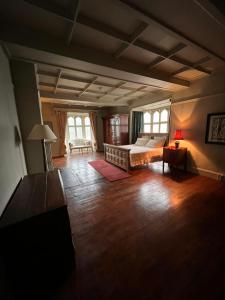 ein Schlafzimmer mit einem Bett in einem Zimmer mit Holzböden in der Unterkunft Llanerchydol Hall Suites in Welshpool