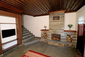 a living room with a stone fireplace and stairs at Akcatepe Dag Evleri in Akcaabat
