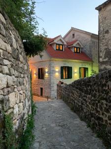 a stone house with a stone wall in front of it at KAŽIN supreme in Kotor
