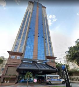 Un grand bâtiment avec une camionnette garée devant. dans l'établissement Golden Flat's - Slaviero Guarulhos, à Guarulhos