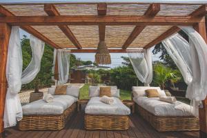 a pergola with wicker couches on a deck at Villa Pietra Estoril Eco Guesthouse in Estoril