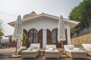 een huis met stoelen en parasols ervoor bij Villa Pietra Estoril Eco Guesthouse in Estoril