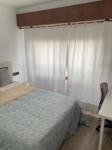 a bedroom with a bed and a table and a chair at Apartamento turístico A Coruña in A Coruña
