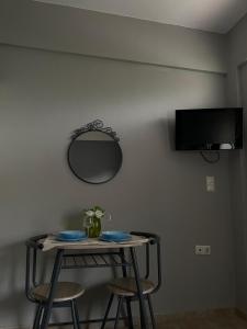a table with two chairs and a mirror on a wall at Souzana Suite Leptokarya in Leptokarya