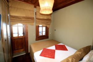 a bedroom with a bed with two red towels on it at Akcatepe Dag Evleri in Akcaabat