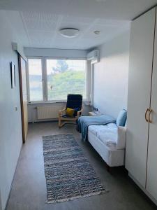 una camera da letto con un letto, una sedia e una finestra di Kampus Sippola a Sippola