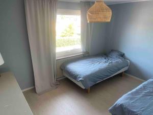 niewielka sypialnia z łóżkiem i oknem w obiekcie Spacious 4 bedroom with garden - Central location w Göteborgu