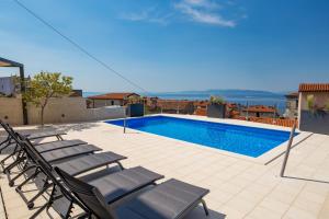 a swimming pool with chaise lounge chairs on a patio at Apartmants Belvedere Rijeka in Rijeka +22 photos