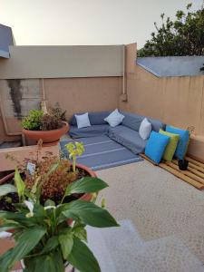 a patio with a blue couch and some plants at Balada dos Mares Vila in Vila do Conde