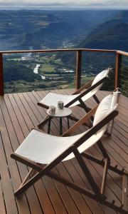 two chairs and a table on a deck at Recanto Ninho das Aguias in Nova Petrópolis