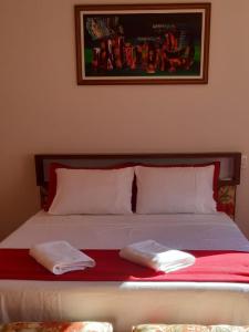 a bed with two white towels on top of it at Recanto Ninho das Aguias in Nova Petrópolis
