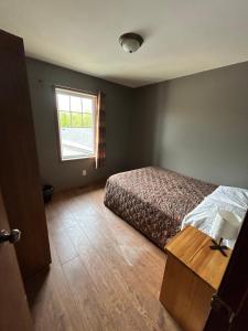 a bedroom with a bed and a window at Betula Lake Resort in Seven Sister Falls