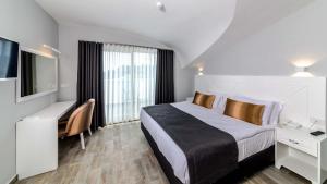 a bedroom with a bed and a desk and a tv at Motto Premium Hotel&Spa in Marmaris