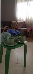 a green coffee table with bowls and flowers on it at La Pedriza II in Enix