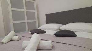 a bedroom with two beds with pillows at Ellamar City Center Apartment 2 in Makarska
