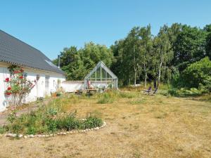 un jardin avec une serre à côté d'une maison dans l'établissement 5 person holiday home in H jby, à Højby