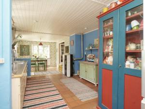 a kitchen with blue and red cabinets and a table at 5 person holiday home in H jby in Højby