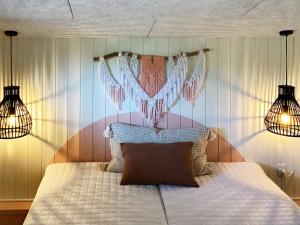 a bedroom with a bed with two lights and two lamps at Holiday home Hvide Sande XXVI in Bjerregård